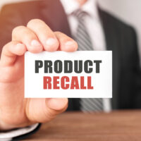 Businessman holding a card with text Product Recall
