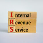 Concept word 'IRS - Internal Revenue Service' on wooden cubes and blocks on a beautiful white background. Business concept, copy space.